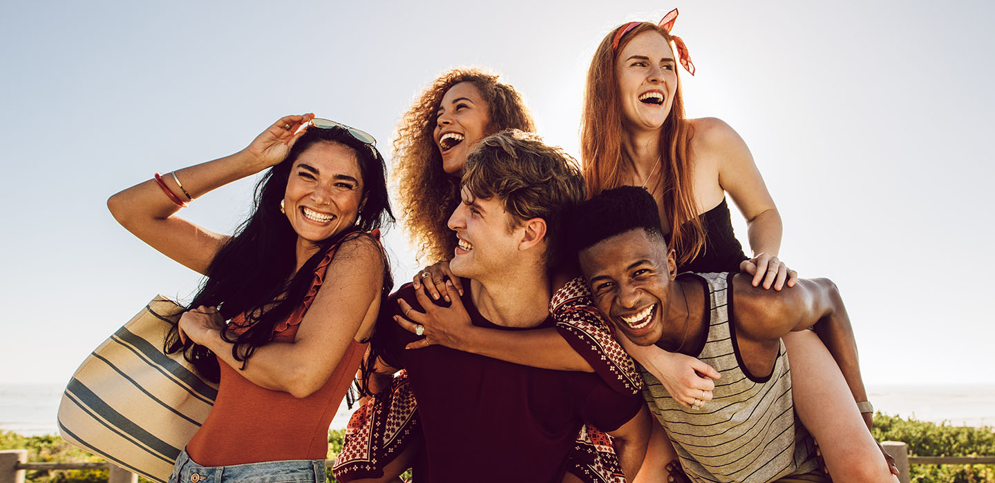 Group of people dressed for summer laughing and smiling
