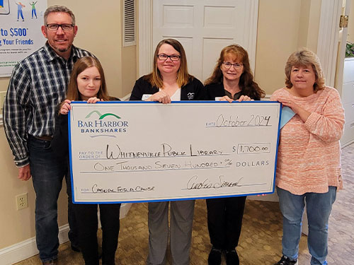 BHBT employees present a donation to Whitneyville Public Library