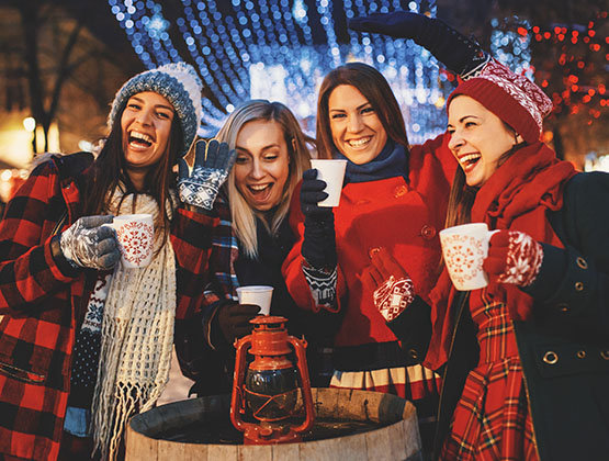 Four women drinking hot chocolate and laughing