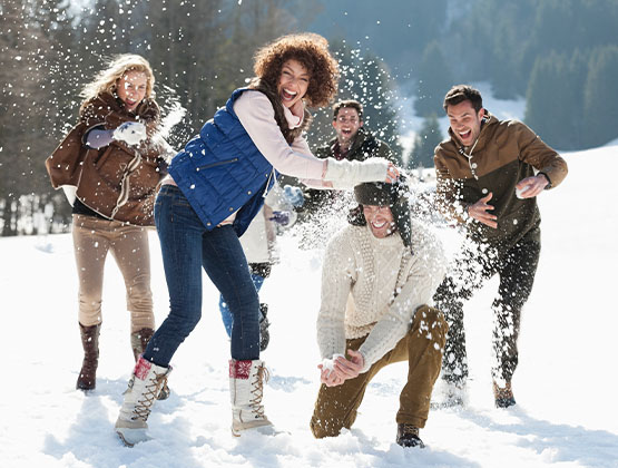 Adults laughing and playing in the snow