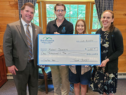 Bar Harbor Bank & Trust employees present Michael Douglass, winner of the Bank’s Honor a Frontline Hero Contest, with a check.