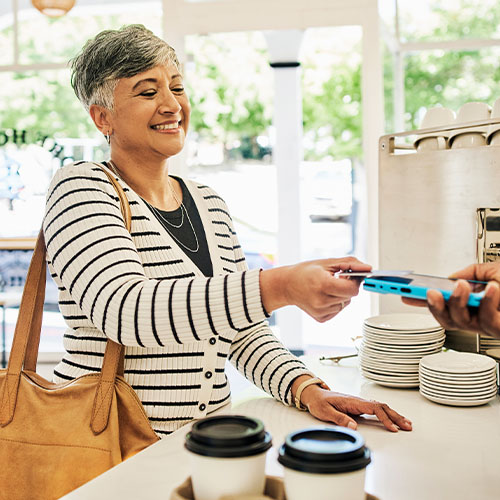 A woman paying for coffee with a credit card