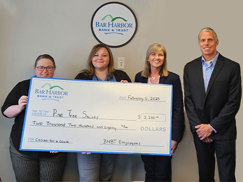 Employees present a donation to Pine Tree Society