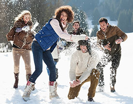 Adults laughing and playing in the snow