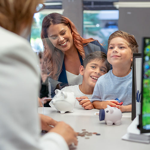 A mother and her two boys at a bank teller window