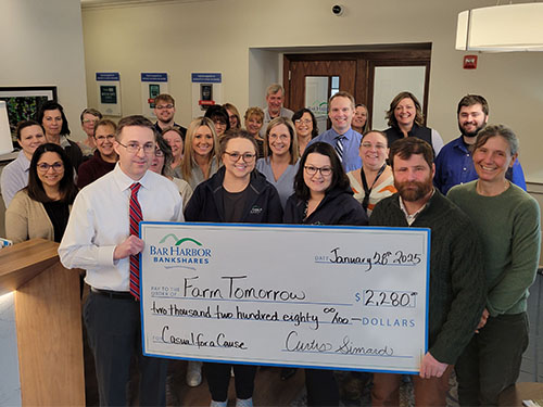 Employees present a donation to Farm Tomorrow