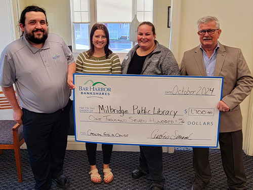 BHBT employees present a donation to Milbridge Public Library