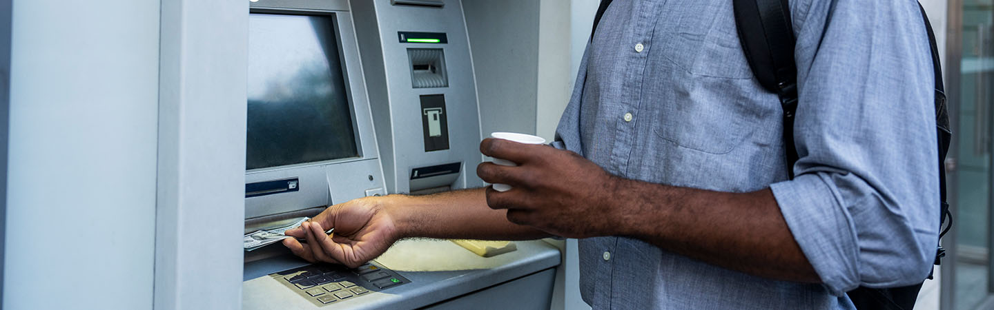 Image on man grabbing cash from an ATM