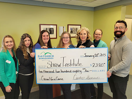 Employees present a donation to Shaw Institute