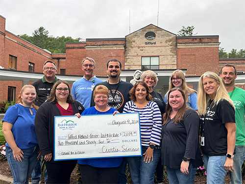 Employees present a donation to Gifford Medical Center