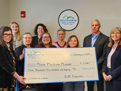 Employees present a donation to Maine Maritime Museum